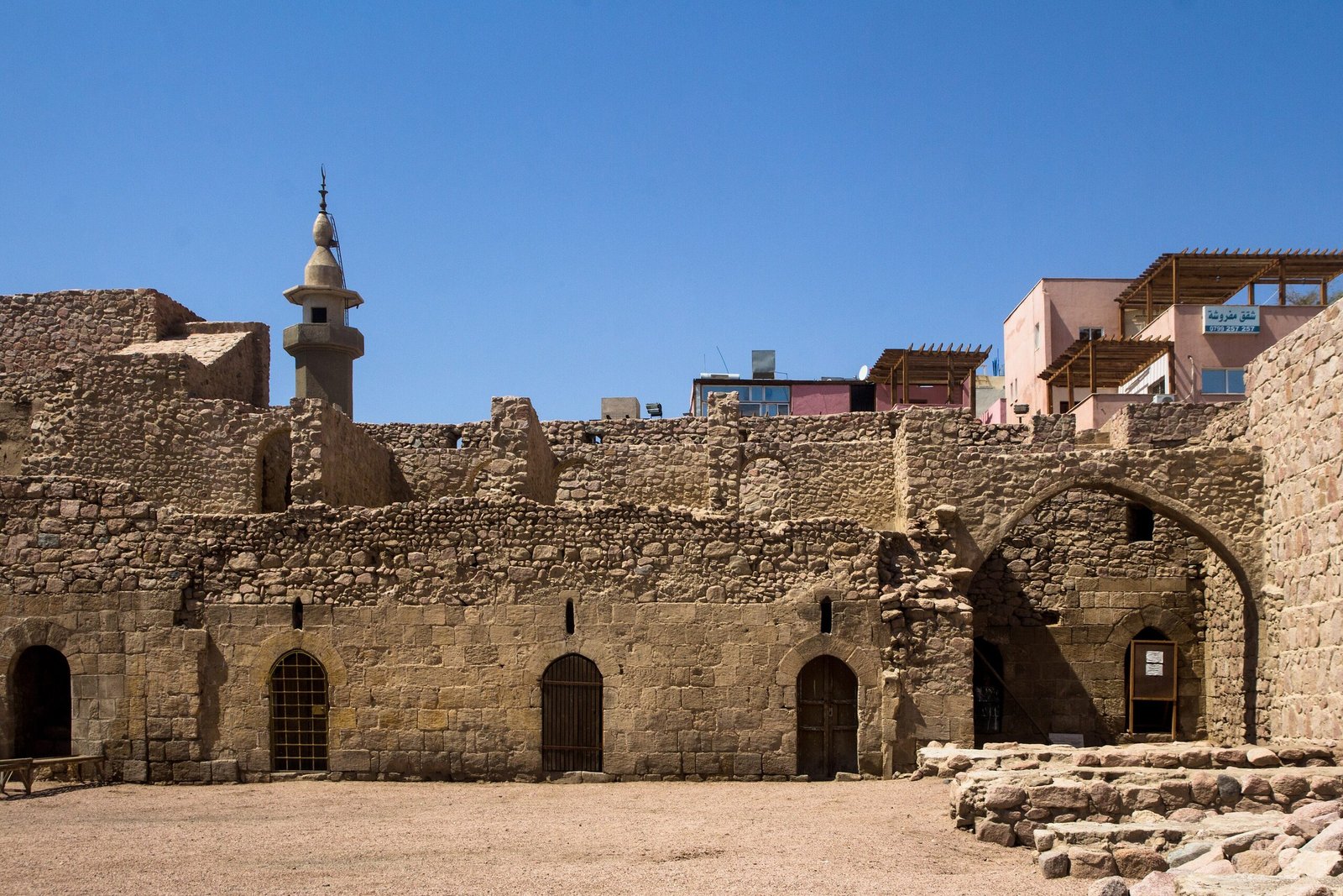 أسوار قلعة العقبة المملوكية وأبراجها وبوابتها تحت سماء ساطعة.