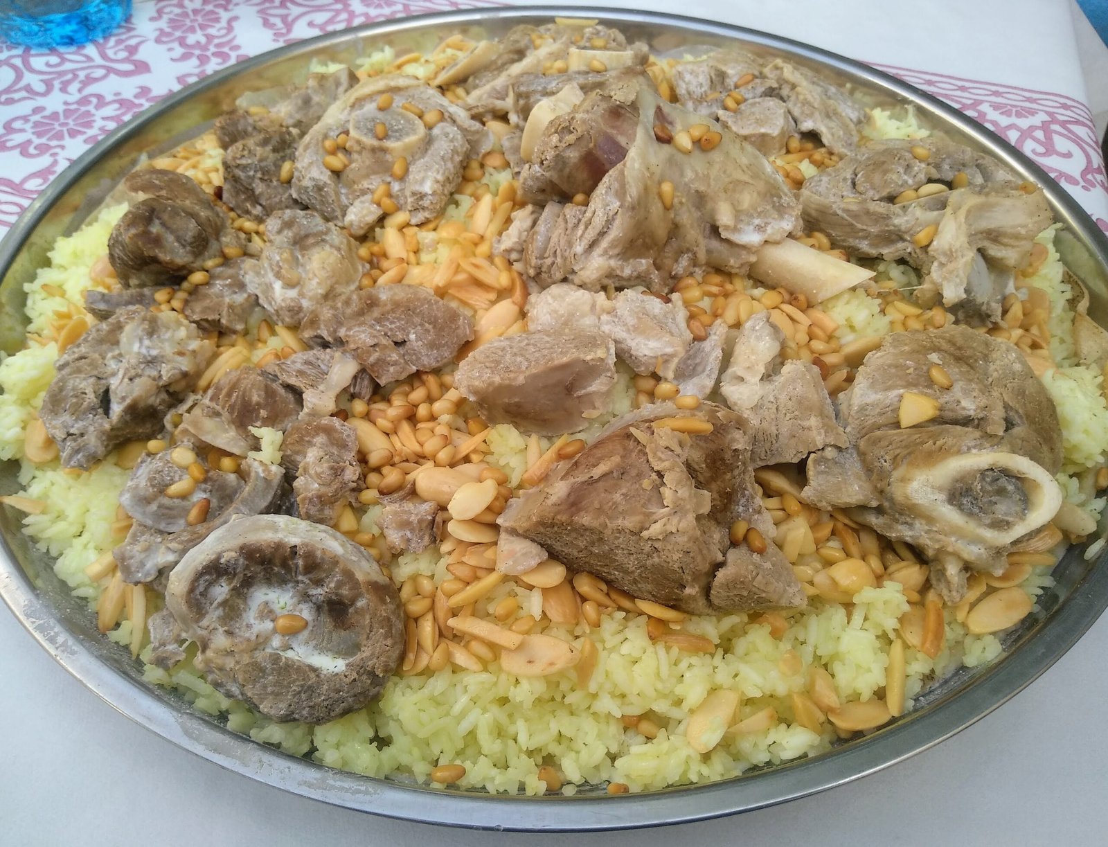 A large communal tray of mansaf — lamb over rice with jameed — set out to share.