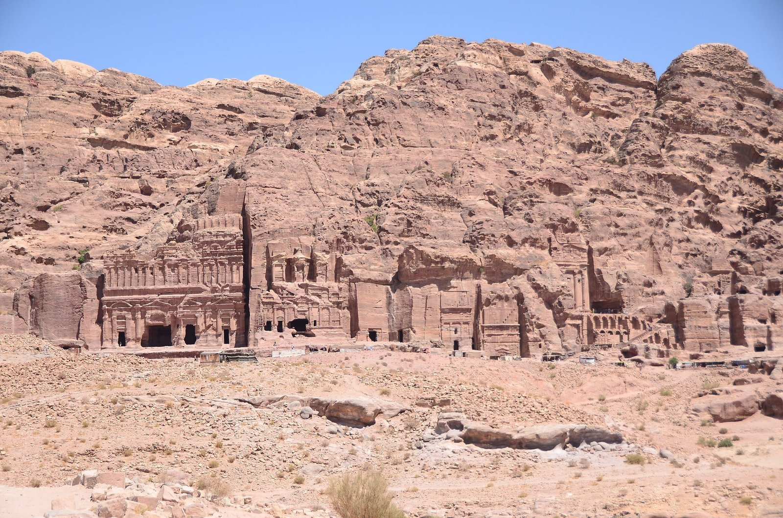 Row of monumental rock-cut Royal Tombs in the cliff face at Petra under a clear sky.