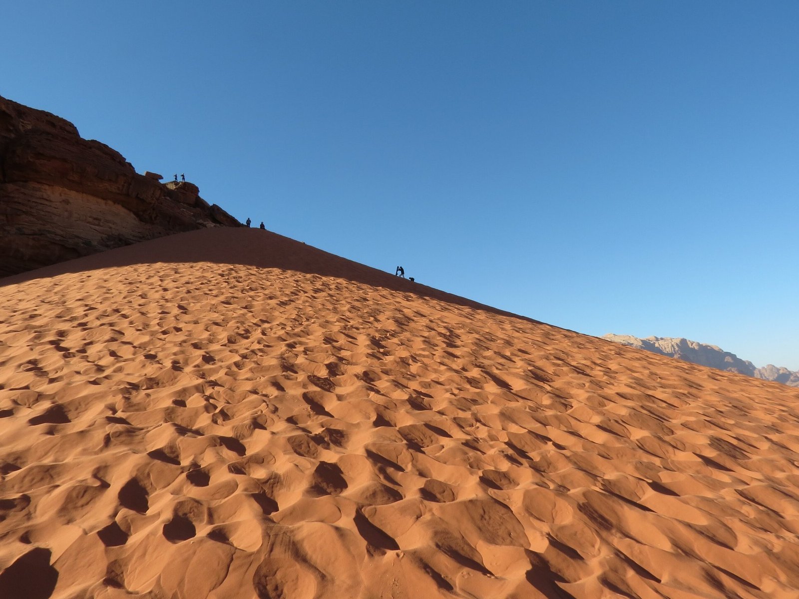 Close view of wind ripples in red sand along a dune ridge in Wadi Rum.